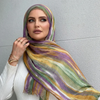 Una mujer vistiendo un pañuelo de hijab floral acuarela multicolor sobre el cuello y los hombros.