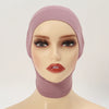 A model wearing a mauve inner hijab cap scarf with long eyelashes and glossy orange-red lips.