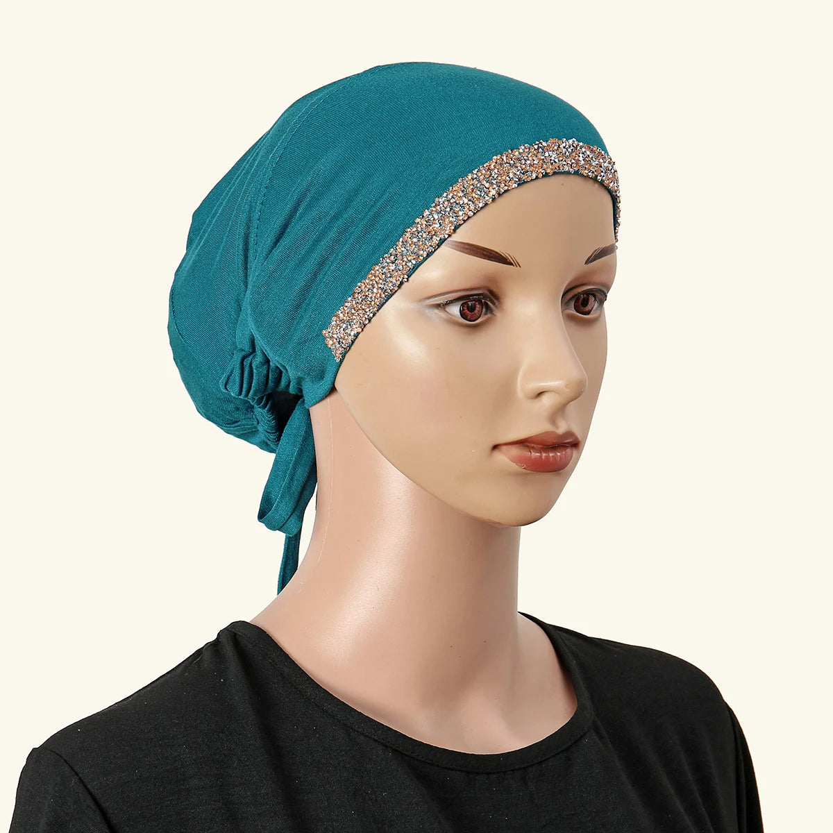 Ein Model trägt einen türkisen Hijab mit Strassbesatz und einem schwarzen Oberteil.