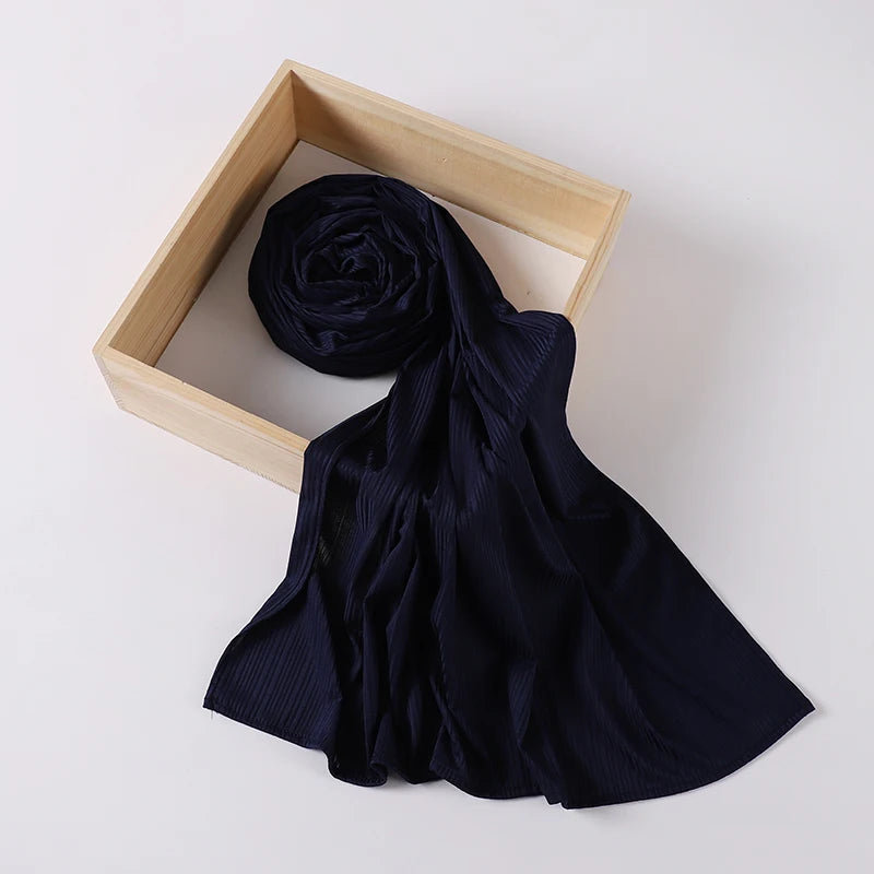 A dark navy ribbed jersey hijab scarf is displayed within a light wooden frame.