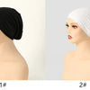 Dos modelos muestran gorros de tela elástica blanco y negro para cubrir la cabeza.