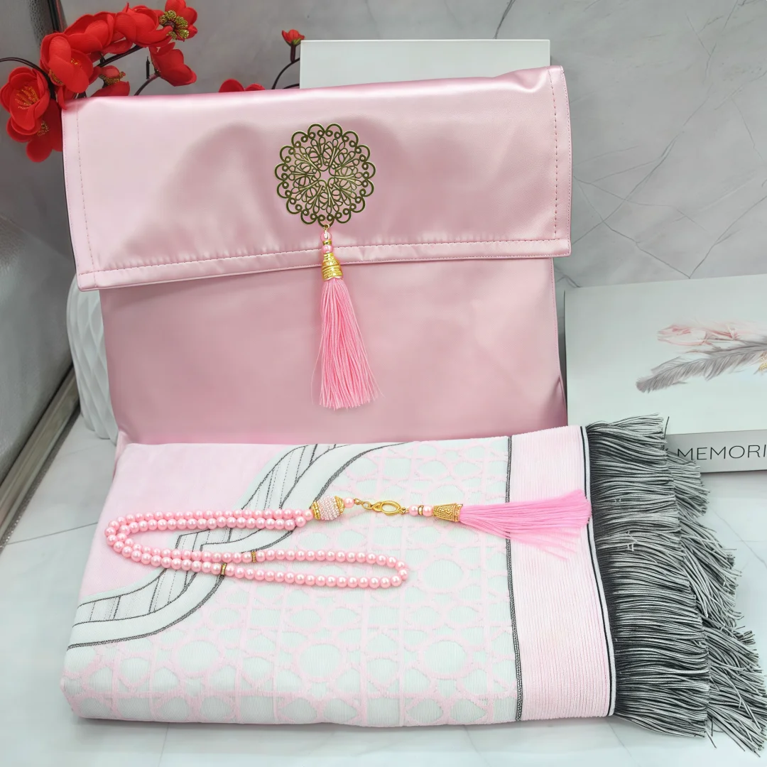 Un juego de tres alfombras de oración musulmanas rosa y blancas con flecos decorativos