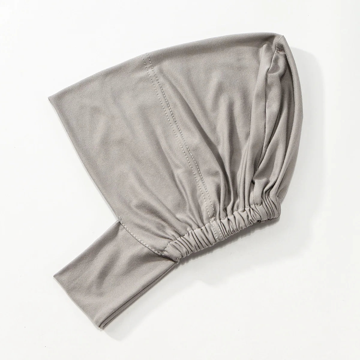 Hijab foulard gris uni plié et exposé sur un fond blanc.