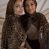 Dos mujeres con pañuelos de estampado de leopardo posando juntas