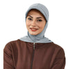 Une femme portant un bonnet hijab de couleur bleu clair et une haut à fermeture éclair marron.