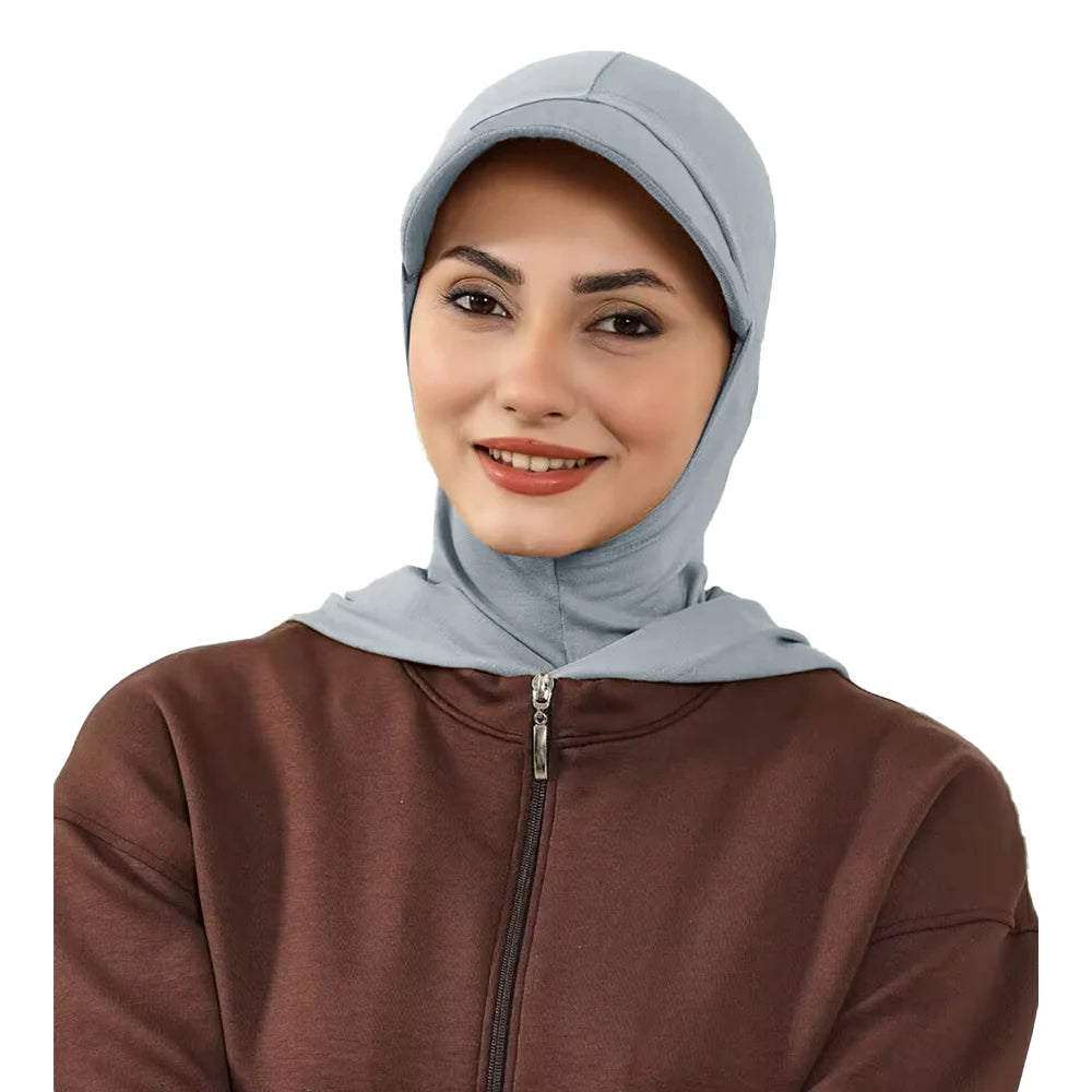 Une femme portant un bonnet hijab de couleur bleu clair et une haut à fermeture éclair marron.