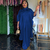 Eine Frau trägt eine königsblaue luxuriöse afrikanische Kaftan-Abaya für den Abend, steht drinnen.