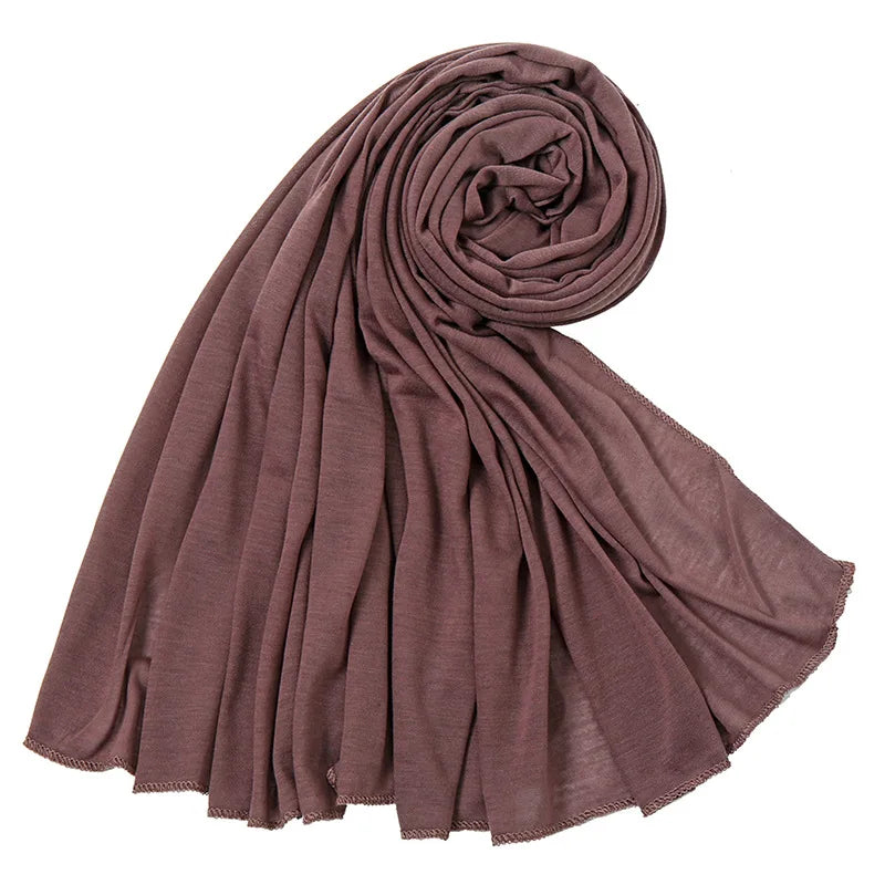 Écharpe hijab en jersey de coton mauve drapée et roulée en spirale.