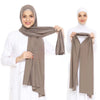 Une femme modélise un foulard instant en jersey beige, élastique, drapé sur sa tête et ses épaules.
