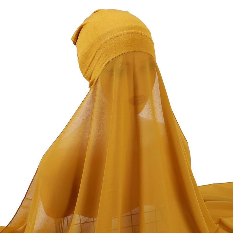 Pañuelo y chal de gasa amarillo mostaza cayendo sobre una superficie.