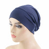 Un foulard élastique bleu marine à la forme de bonnet, exposé sur un mannequin.