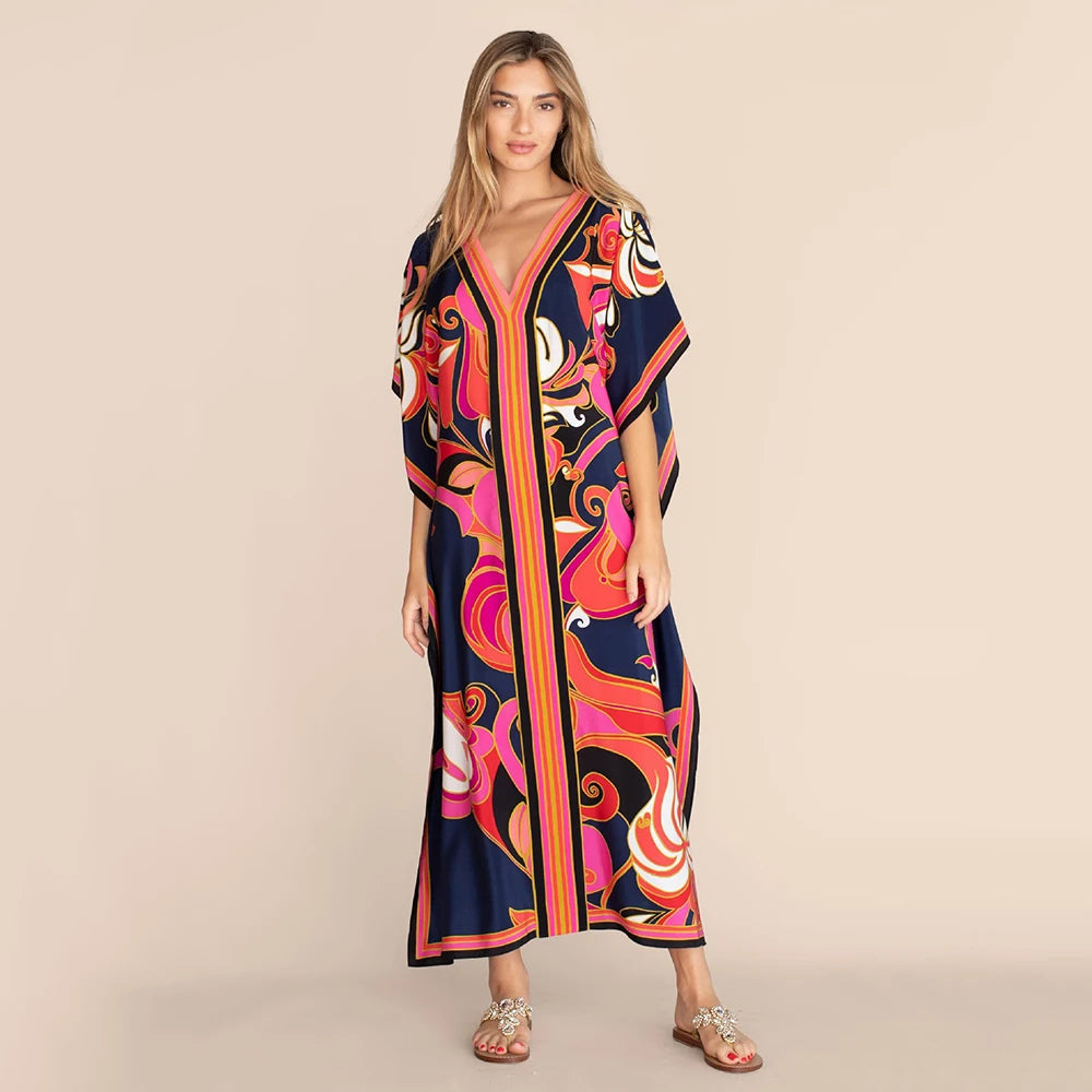 Eine Frau modelliert ein leuchtend gemustertes marokkanisches Batwing-Kaftan-Überkleid in tiefen Blau- und Orangetönen.