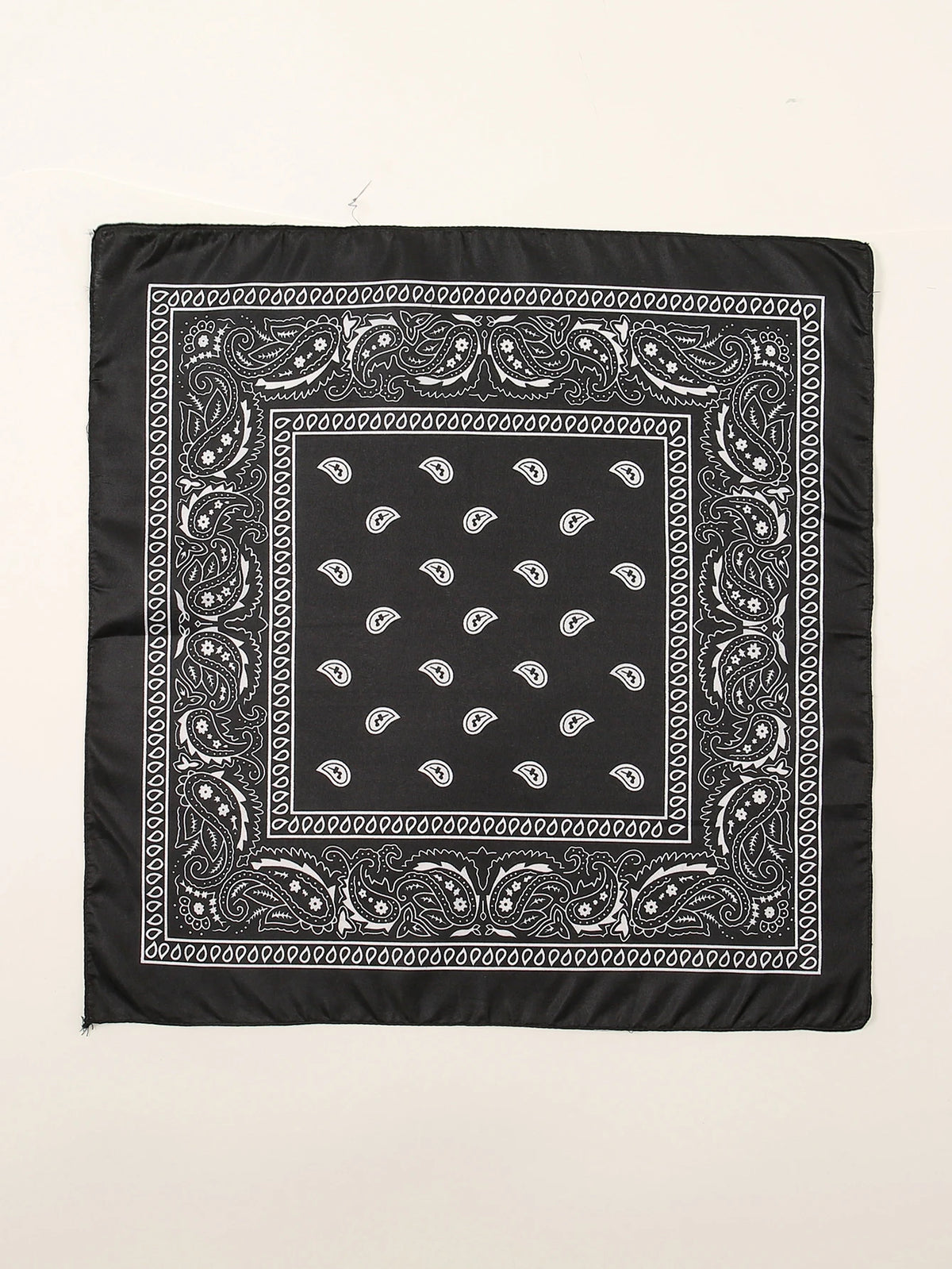 Tissu noir carré avec des motifs paisley et floraux blancs complexes sur fond clair