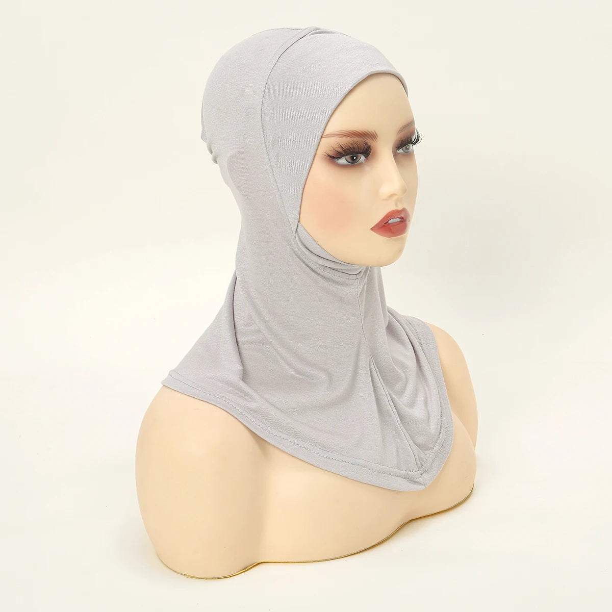 Ein Model trägt eine hellgraue, dehnbare Baumwoll-Hijab-Kappe mit voller Bedeckung.