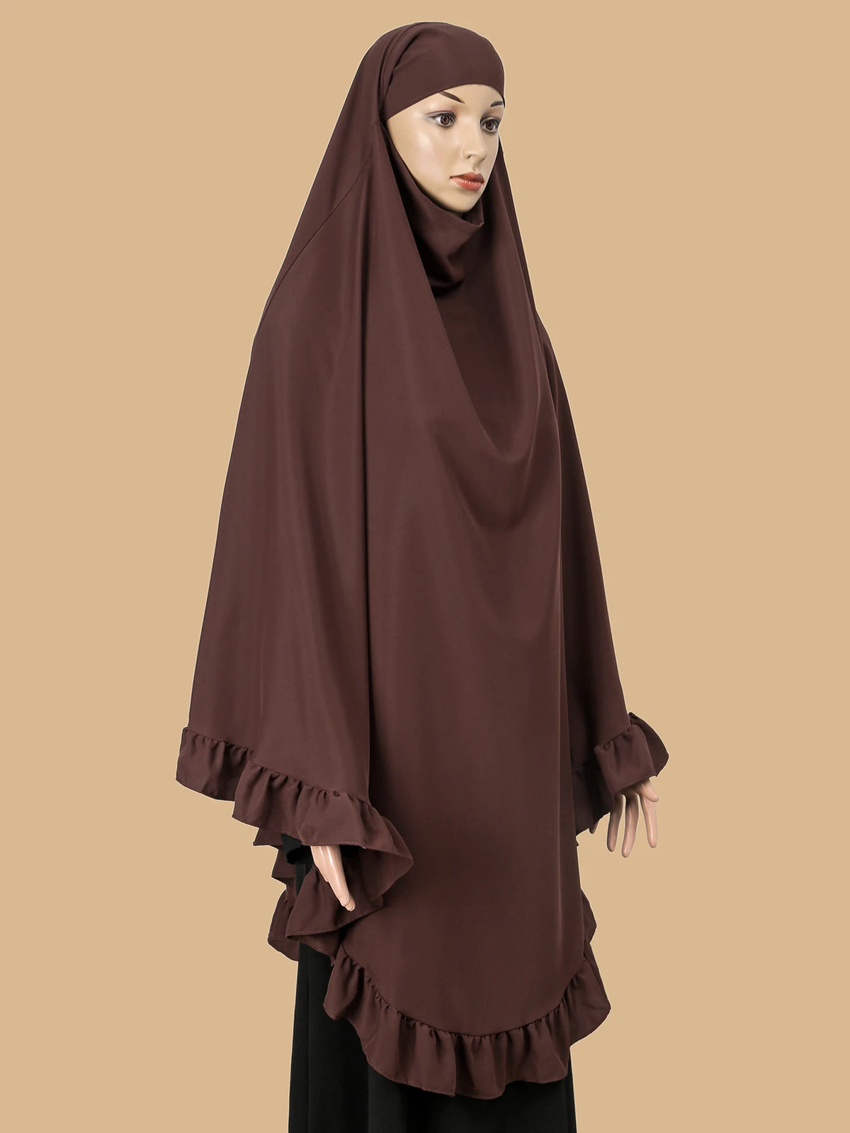 Eine Frau trägt einen dunkelbraunen, mit Rüschen verzierten, strassbesetzten Hijab.