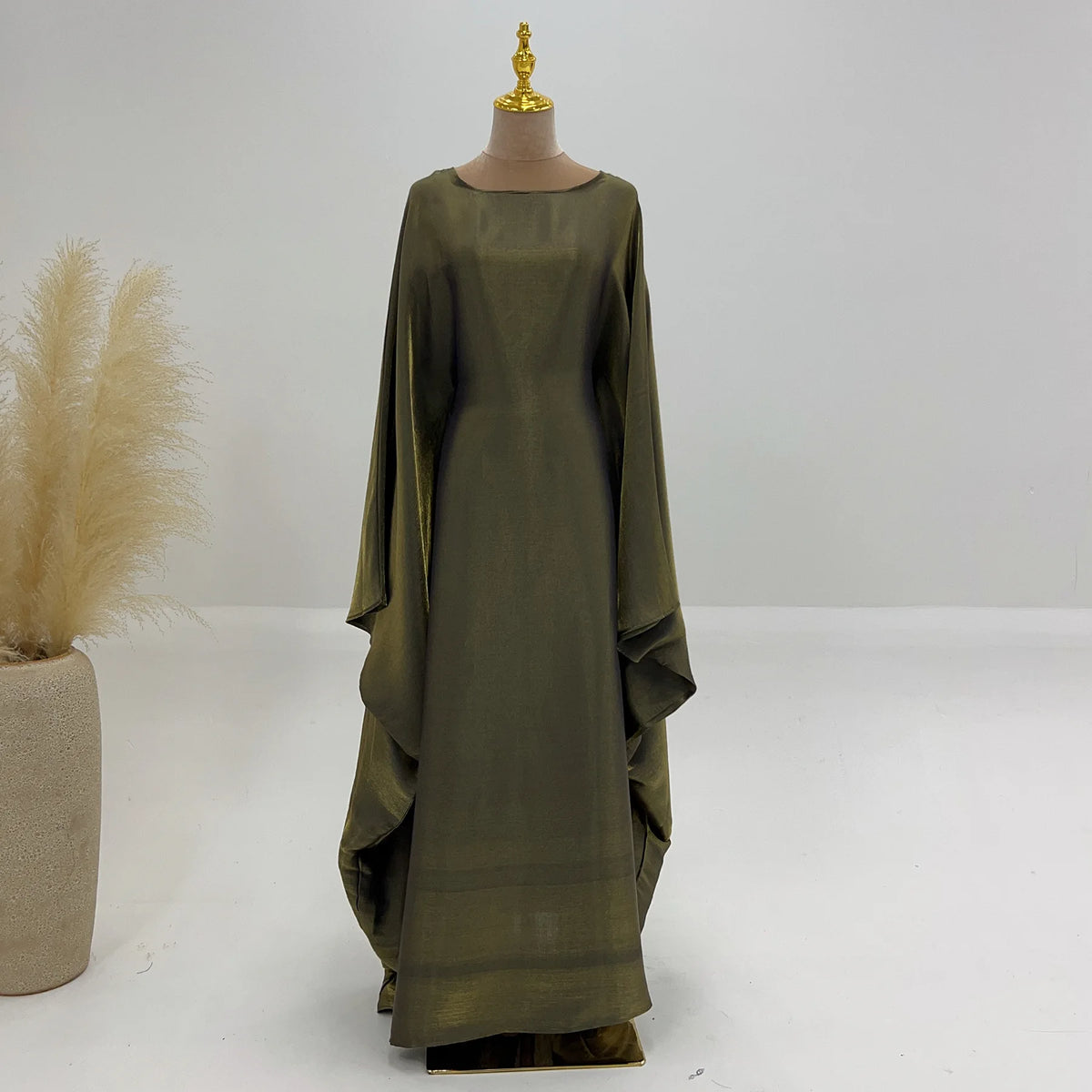 Elegante olivgrüne Langarmabaya auf einem Mannequin.