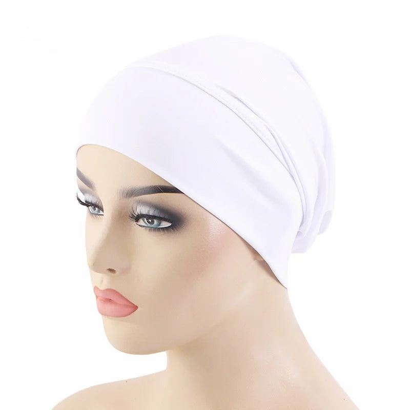 Un foulard élastique blanc porté en bonnet sur un mannequin de tête.
