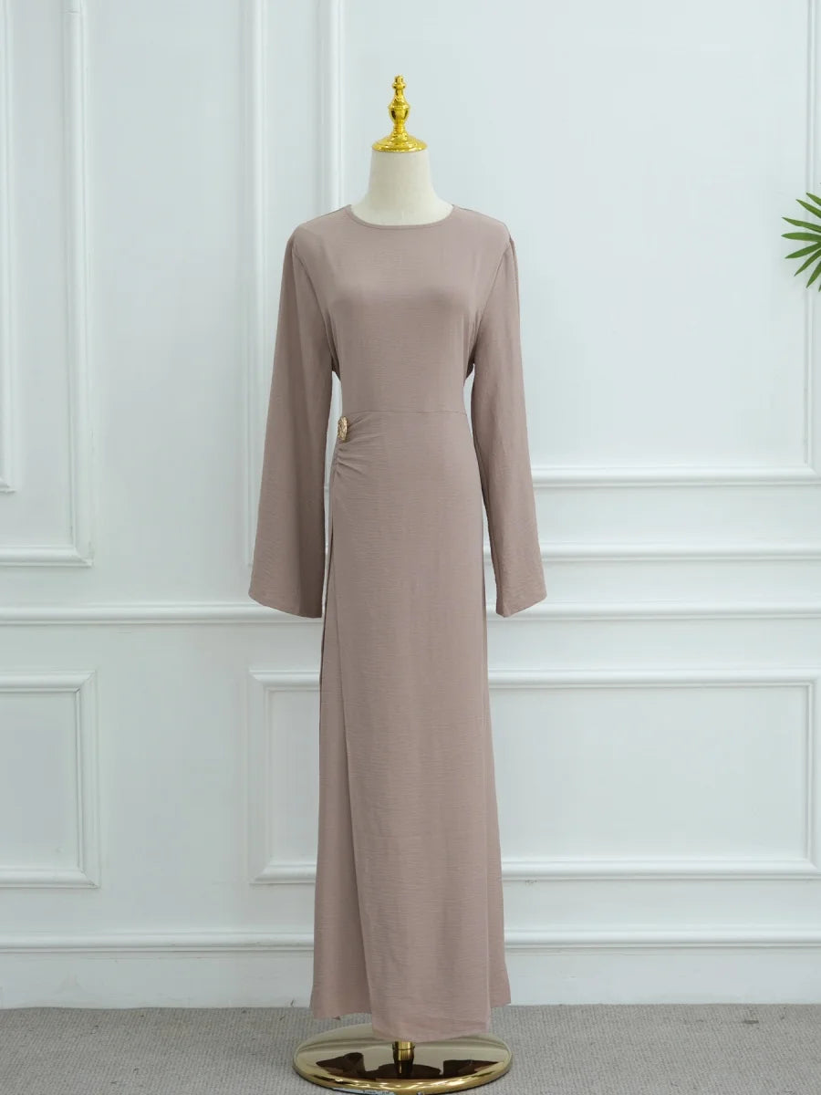 Une abaya beige élégante, longue, présentée sur un mannequin.