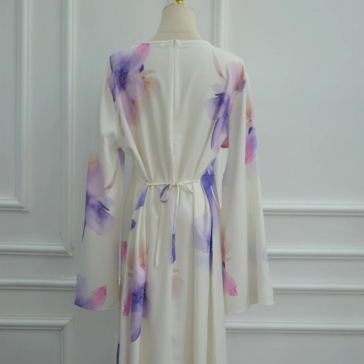 Rückansicht eines eleganten weißen Abayas mit lila und rosa floraler Stickerei