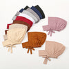 A collection of various colored inner hijab caps and scarves laid out on a white background.