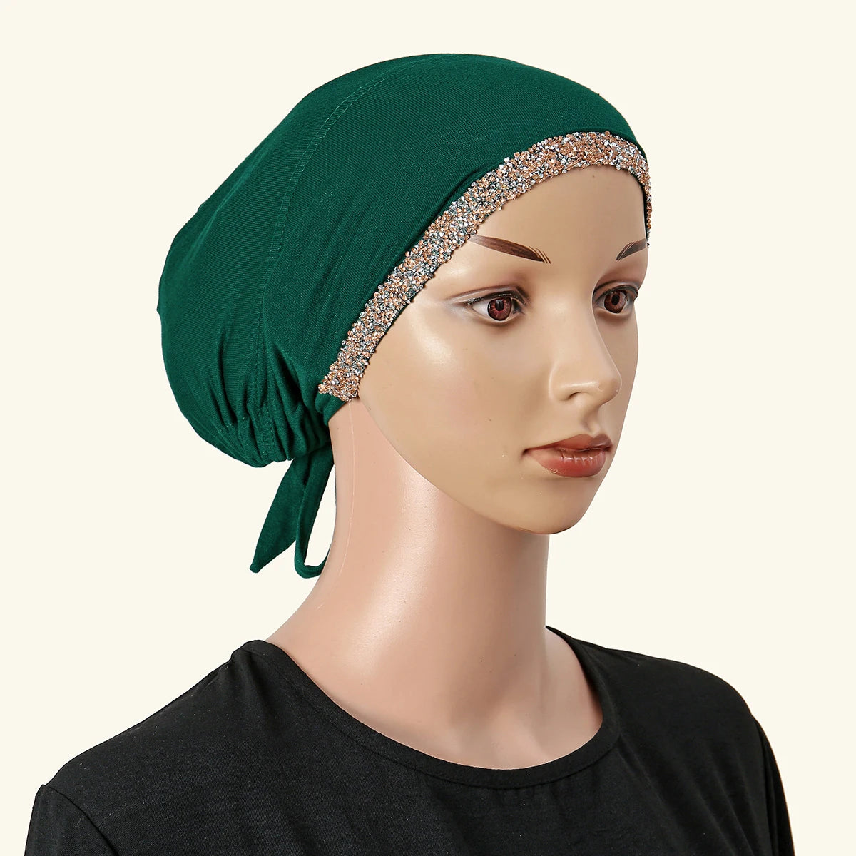 Ein Model trägt einen dunkelgrünen muslimischen Hijab mit einem funkelnden Strass-Haarreif und einem schwarzen Oberteil.