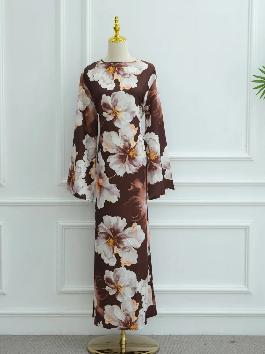 Braun-cremefarbener Blumenmuster-Abaya auf einem Mannequin vor einer weißen Paneelwand.