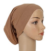 Primer plano de un gorro/pañuelo de modal de algodón suave y elástico color canela, mostrado en un maniquí de cabeza.