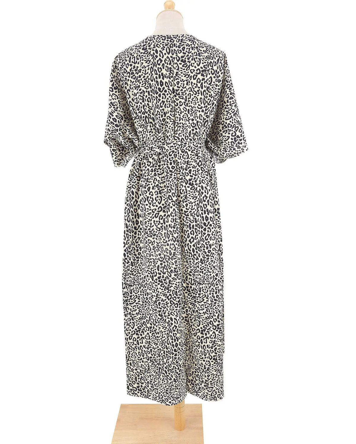 Ein langes Kleid mit schwarz-weißem Leopardenmuster, langen Ärmeln und fließender Silhouette.