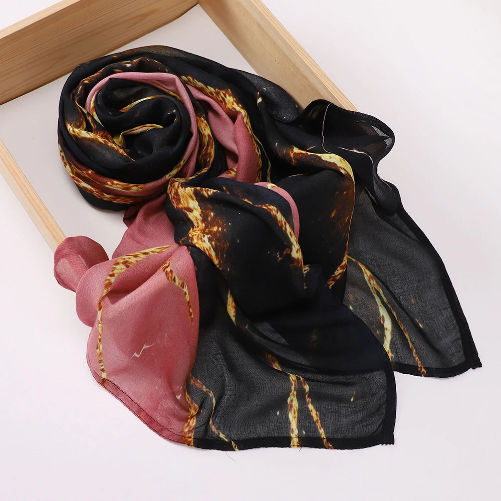 Voile hijab à imprimé noir et rose drapé sur un cadre en bois.