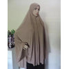 Una mujer vistiendo un pañuelo de hiyab de jersey beige oversize, en un retrato de cuerpo completo.