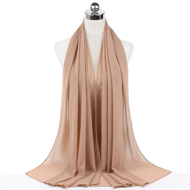 A beige chiffon hijab scarf draped around a mannequin's neck.