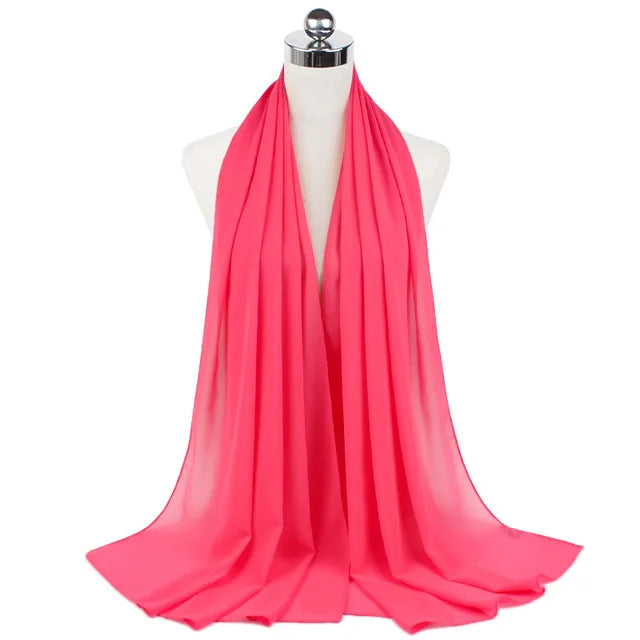 A bright pink chiffon hijab scarf draped around a mannequin's neck.