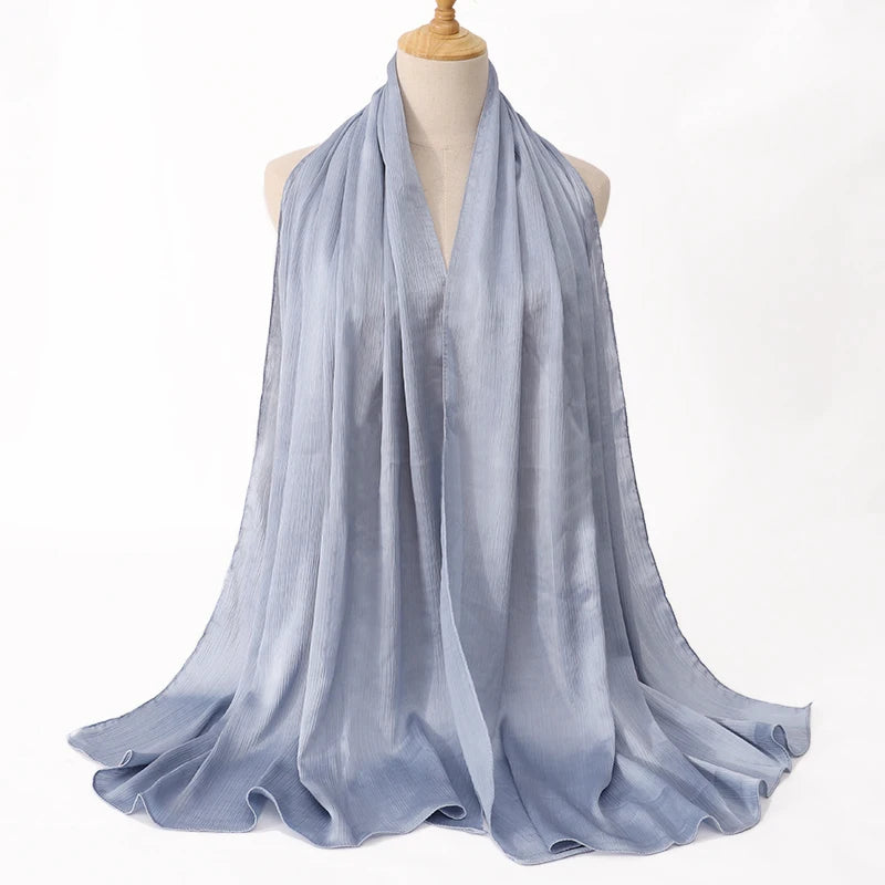 Hellblaue Satin-Crinkle-Hijab-Schal um den Hals eines Mannequins drapiert