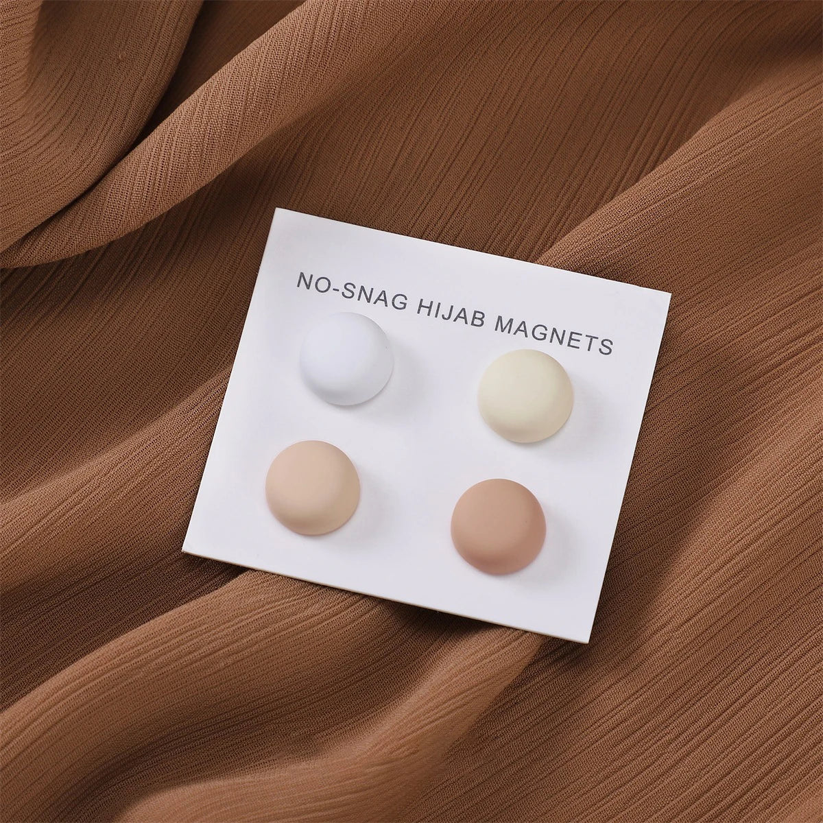 Weiße magnetische Hijab-Pins mit beigen und cremefarbenen matten Silikonkugeln auf einer weißen Karte.