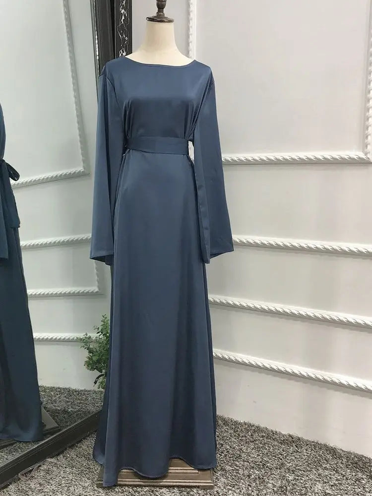 Dunkelblaue, fließende, bodenlange Abaya-Kleid mit Gürtel und ausgestellten Ärmeln auf einem Mannequin.
