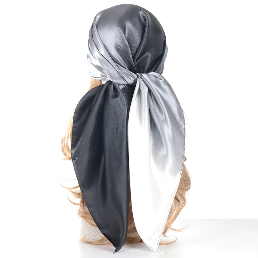 Écharpe satinée avec un dégradé noir et argent, nouée en nœud.