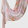 A flowing, sheer linen hijab scarf featuring a soft watercolor print of pink and orange floral branches.