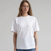 Una modelo vistiendo una camiseta básica blanca de algodón oversize de verano y jeans azules.