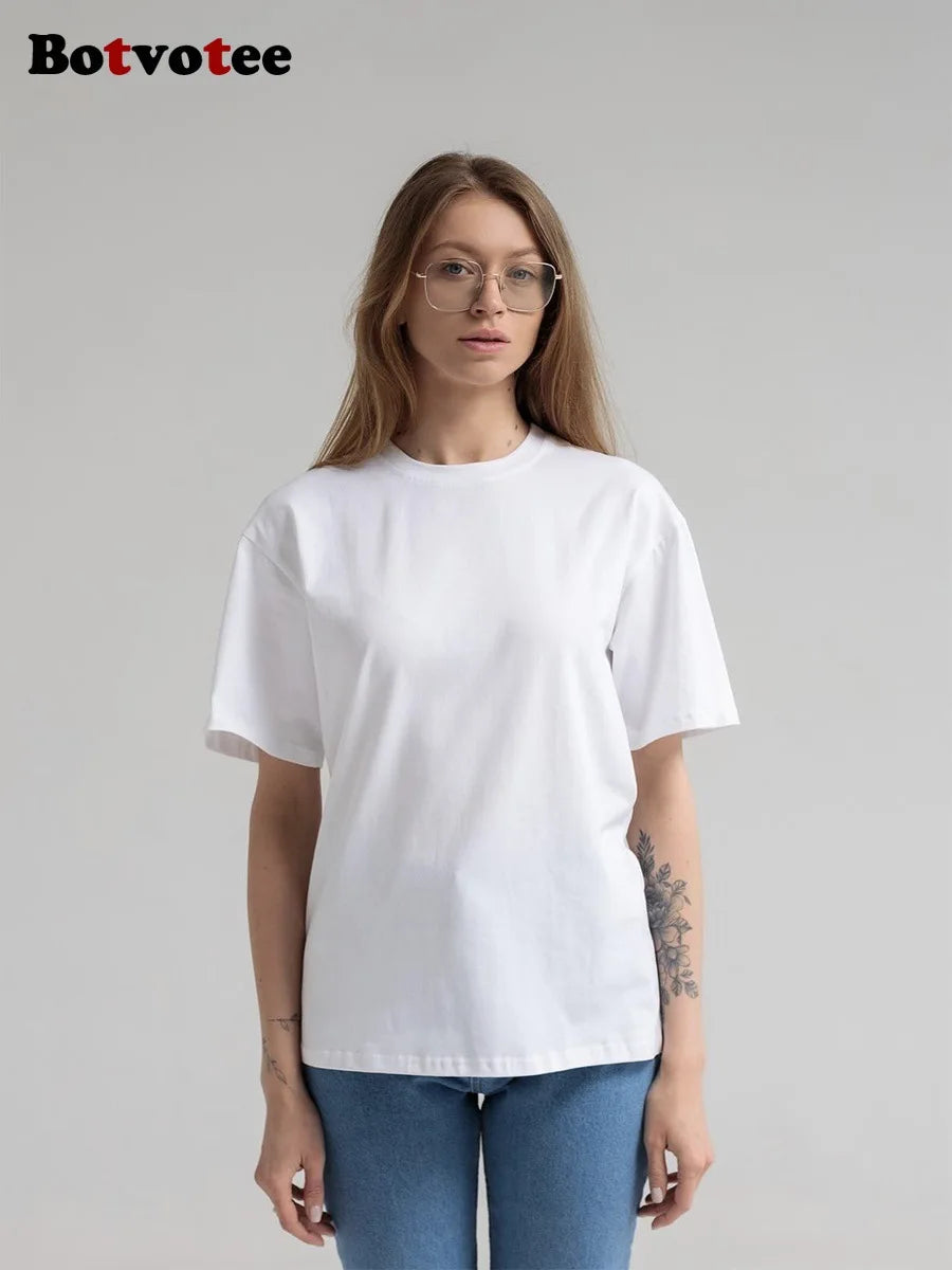 Una modelo vistiendo una camiseta básica blanca de algodón oversize de verano y jeans azules.