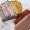 Eine Kollektion von gekräuselten Jersey-Hijab-Schals in Rosa-, Beige- und Olivgrüntönen.