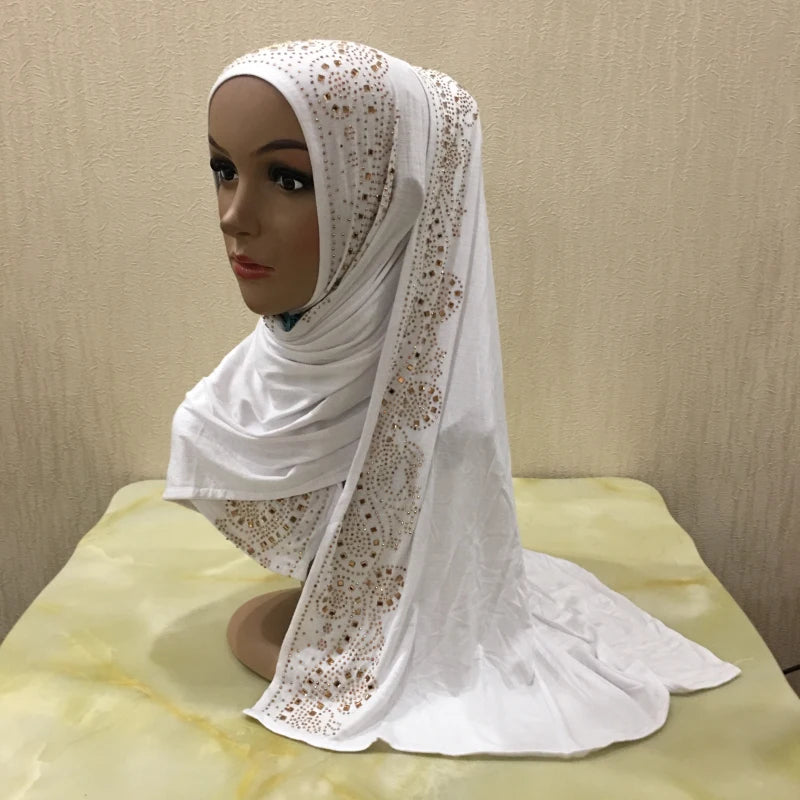 Une écharpe de maillot blanche ornée de cristaux est drapée autour du cou et de l'épaule d'un mannequin.
