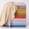 Ein Stapel von Jersey-Hijabs in verschiedenen Beigetönen, Olivgrün, Braun und Pink.