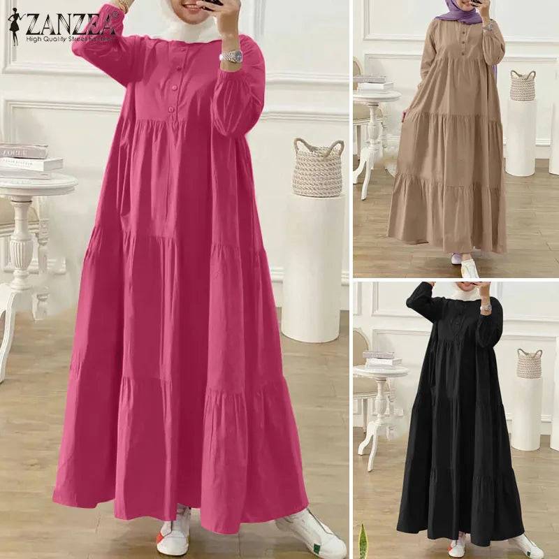 Eine Frau modelliert ein langes, fließendes pinkes muslimisches Kaftan-Kleid mit weißem Kragen und silberner Schmuck.