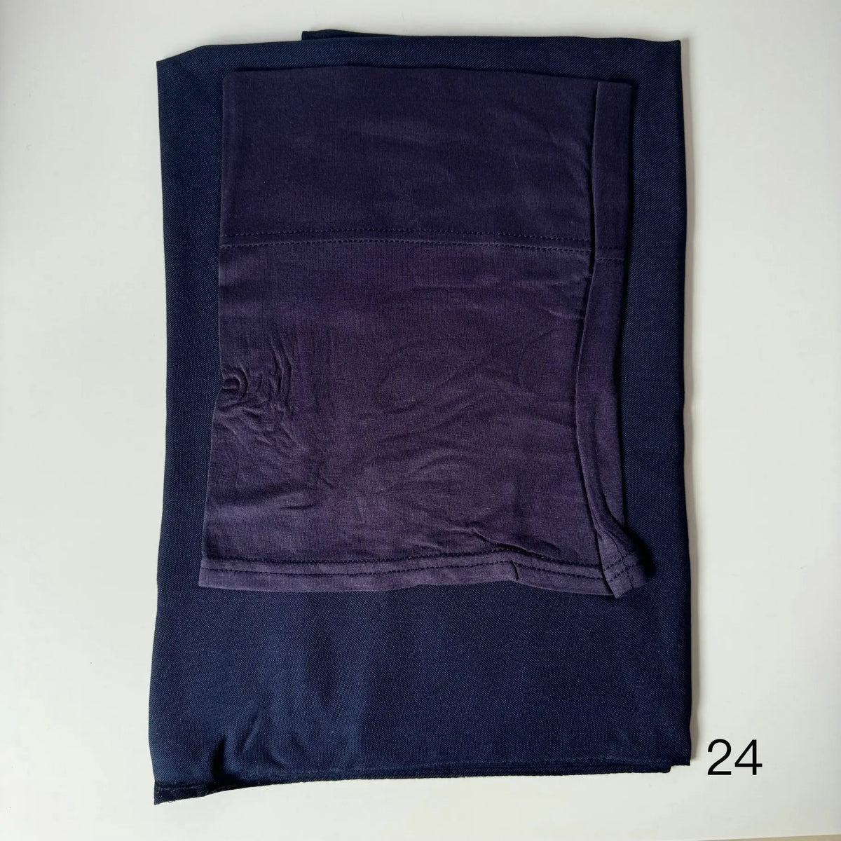 A dark navy blue soft modal rayon hijab set folded neatly on a white surface.