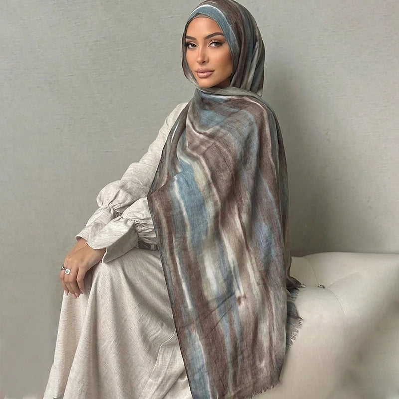 Una mujer usando un pañuelo hijab floral de acuarela bohemio sobre su cabeza y hombros.