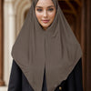 Une femme portant un foulard instant uni marron et des vêtements noirs.