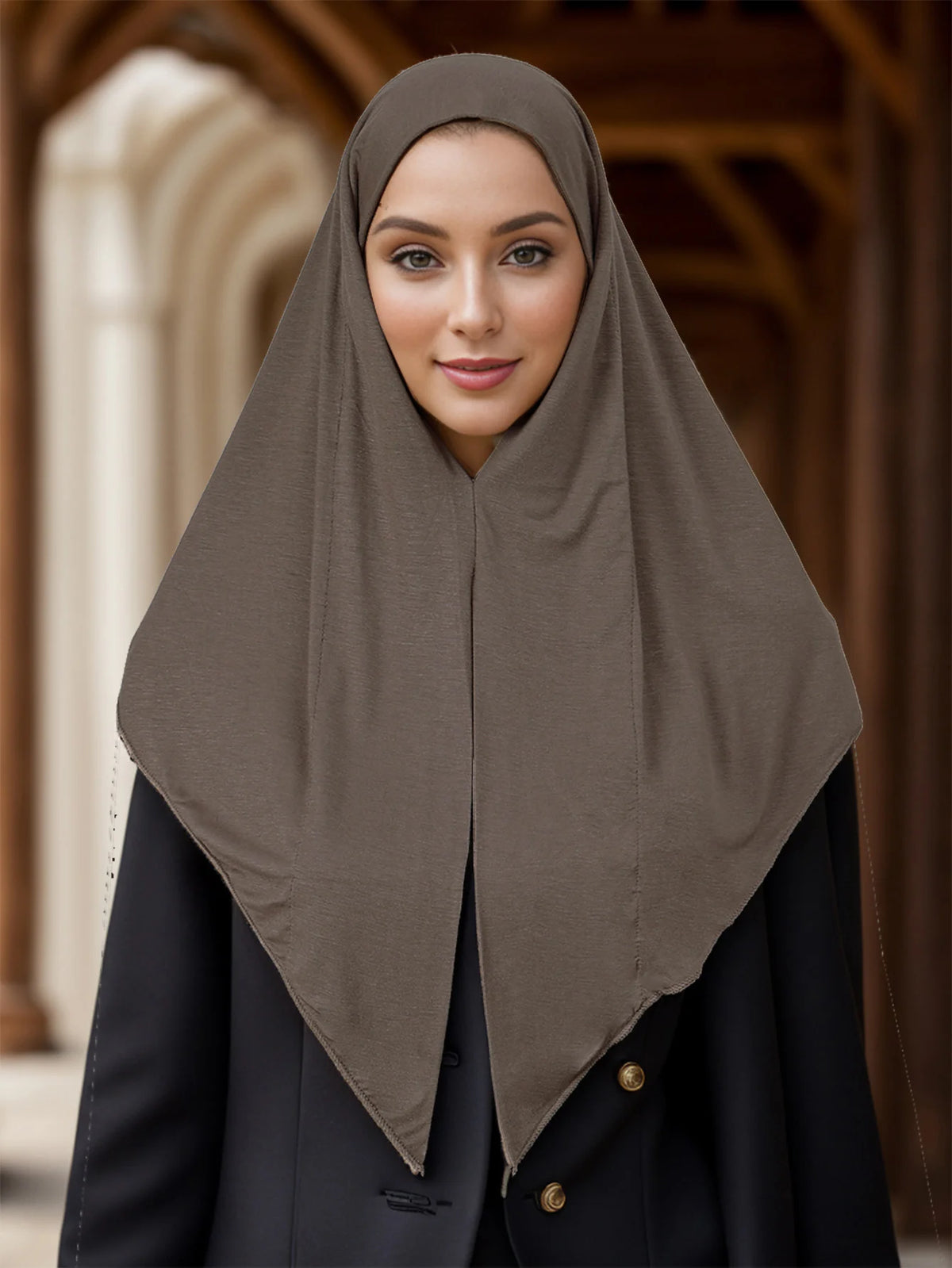 Une femme portant un foulard instant uni marron et des vêtements noirs.