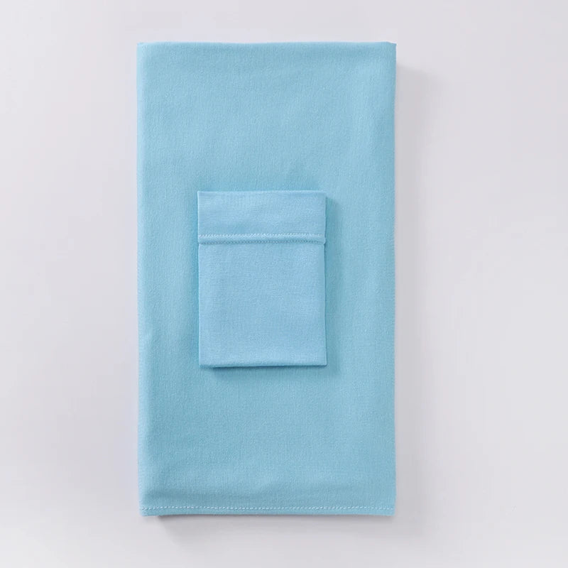 Pañuelo conjunto a juego de dos piezas de jersey azul claro, doblado cuidadosamente sobre una superficie blanca.