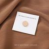 Set of six cream-colored no-snag hijab magnets displayed on brown fabric.