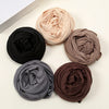 Fünf gerollte Jersey-Hijab-Schals in Schwarz, Beige, Taupe, Grau und Braun auf weißem Untergrund.